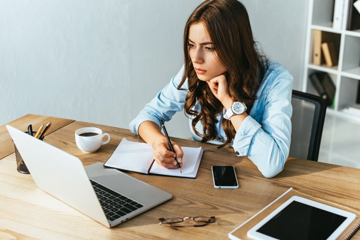 Concentrated Woman At Tabletop With Laptop Taking Part In Webina