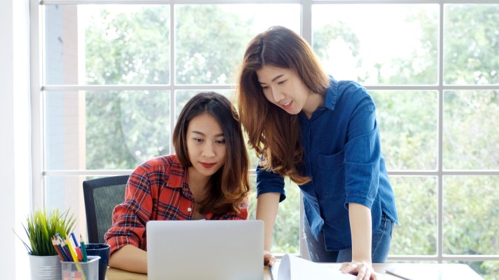 Two Young Asian Women Working With Laptop Computer At Home Offic