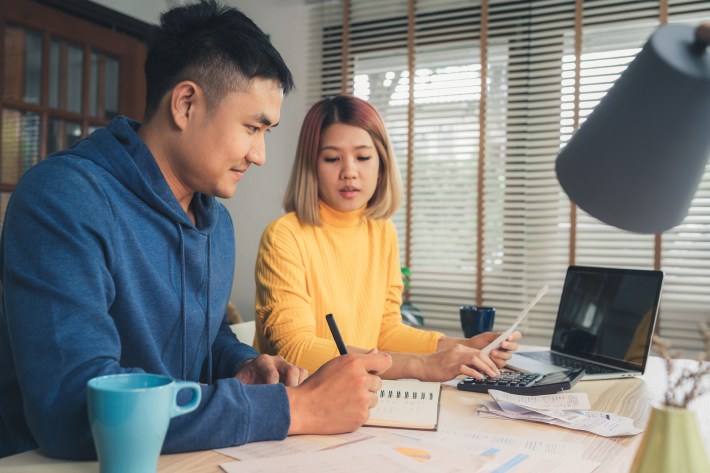 Young Asian Couple Managing Finances, Reviewing Their Bank Accou