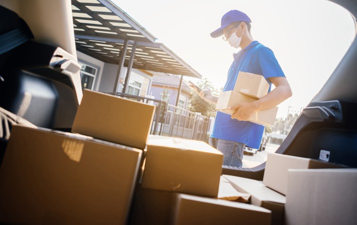 Man wearing a mask delivering packages