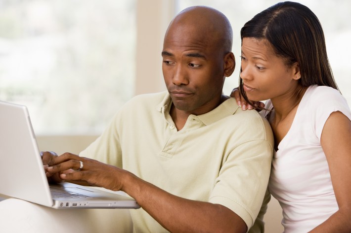 Couple In Living Room Using Laptop