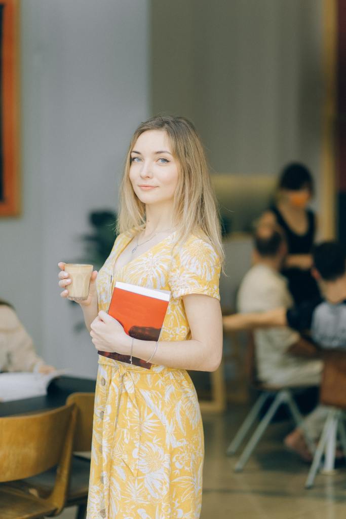 A confident young woman holding a book